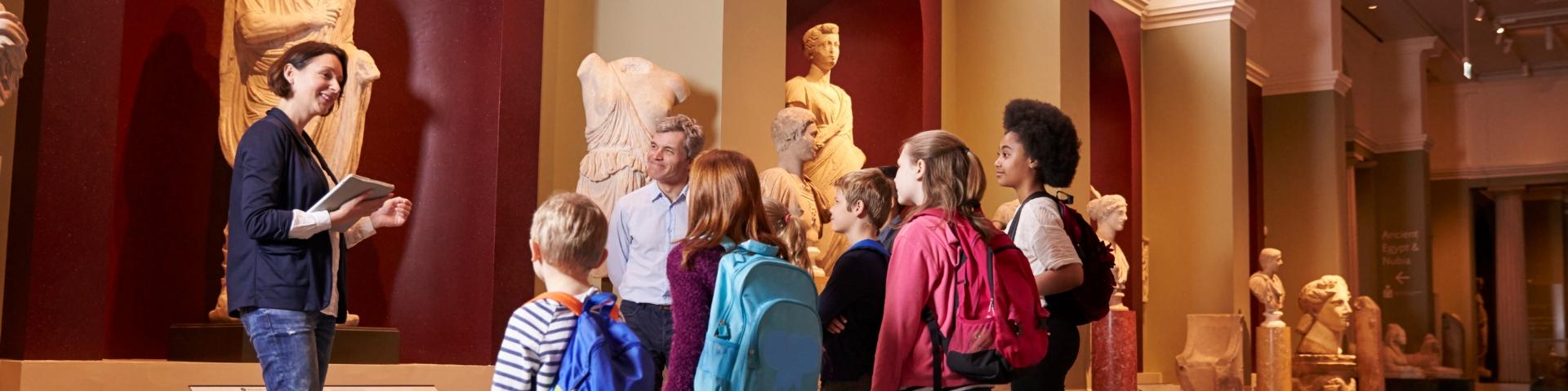 A person leading a children's tour through a museum 